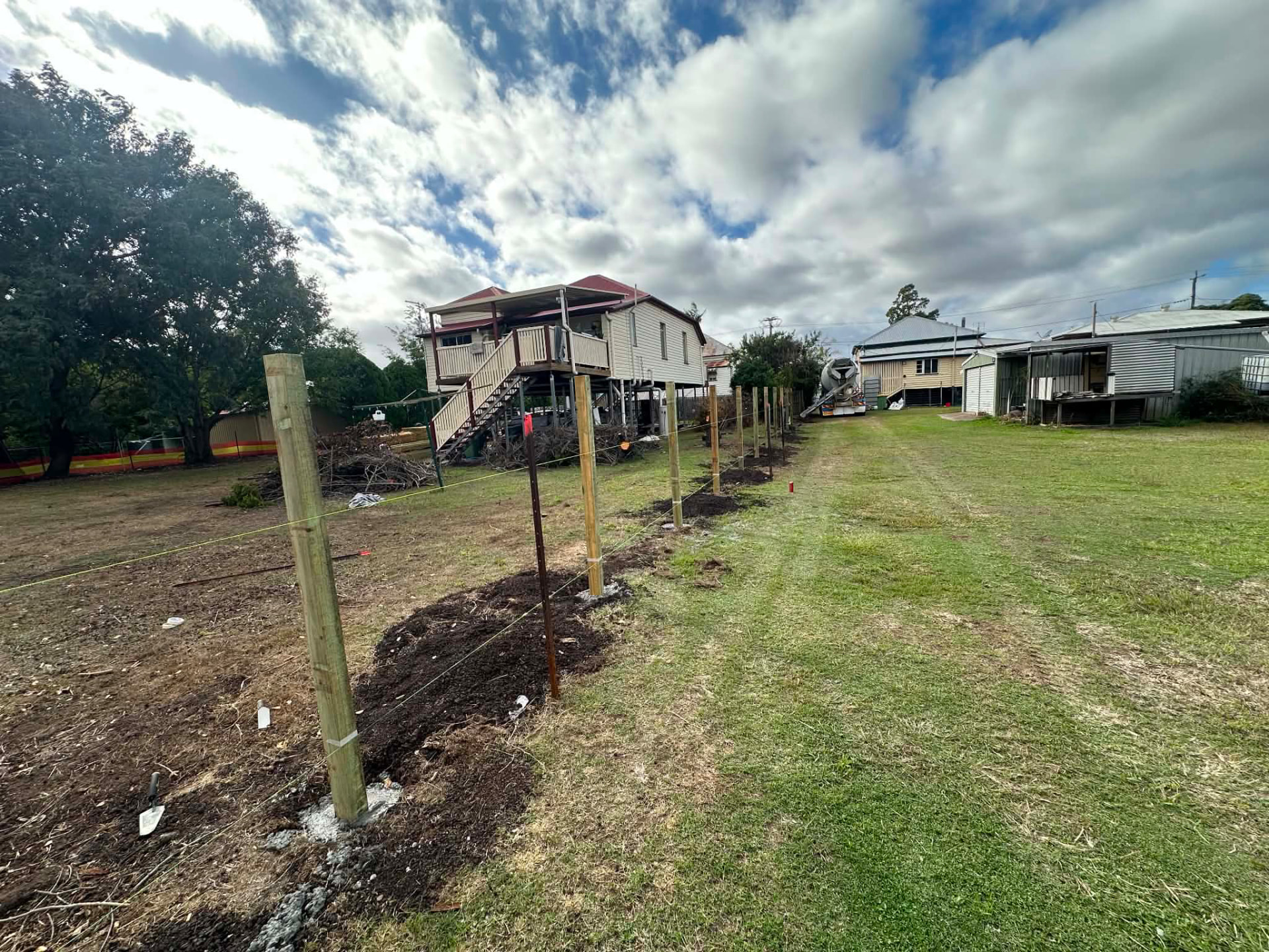 New fence posts concreted along a property boundary line