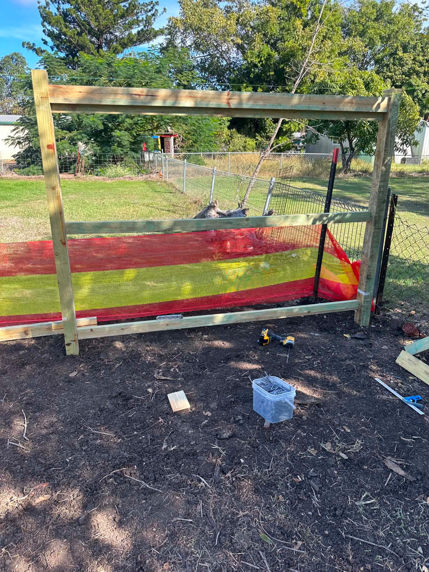 Timber fence frame under construction with safety mesh